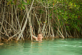 Caucasian boy swimming in river