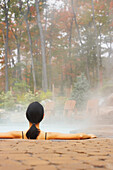 Rear view of woman sitting in hot tub