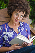 Mixed race woman reading book