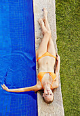 Caucasian woman relaxing by swimming pool