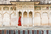 Woman in sari walking through cloister, Pushkar, Rajasthan, India