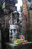 Offerings at base of Hindu statue, Ubud, Bali, Indonesia
