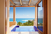 Window overlooking infinity pool and ocean