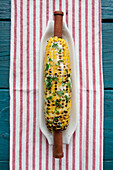 Grilled Corn with Herb Butter on Striped Towel, High Angle View