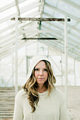 Portrait of Woman in Hooded Sweater Standing in Greenhouse