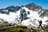 Climber traversing in front of Mount Formidable during the Ptarmigan Traverse , North Cascades, Washington