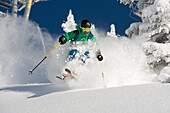 A man skiing powder on a beautiful sunny day in Utah.