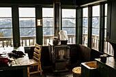 Inside an old fire lookout in the winter, looking into the Spanish Peaks around Big Sky, Montana.