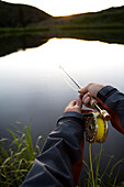 As the sun sets on a Wyoming pond, an angler strips in his line