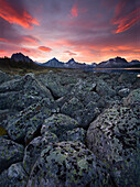 Large stones covered in a variety of lichens dominate the foreground beneath an impressive sunrise sky along the shore of Amethyst Lake in Jasper National Park, Alberta, in mid October.