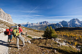 Hikers admiring the landscape of the Dolomites in its autumn colours, South Tyrol, Italy, Europe