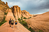 Trekkers walking along the Slickrock trail near, Moab, Utah, United States of America, North America