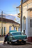 Street scene with colonial buildings and classic green American car, Trinidad, Cuba, West Indies, Central America