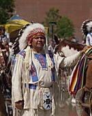 North American Indian man in traditional dress with beads, fur and feathers, at Calgary, Canada, North America