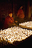 Monks light butter lamps on an auspicious night, Boudha stupa, Bodhnath, Kathmandu, Nepal, Asia