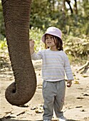 Two year old girl and the elephant that will take her on safari, at the Island Jungle Resort hotel, Royal Chitwan National Park, Terai, Nepal, Asia