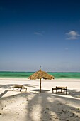 A thatched umbrella and traditional coconut wood sunbeds on Paje Beach, Paje, Zanzibar, Tanzania, East Africa, Africa