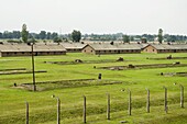 Wooden sheds, formerly stables for horses, that each held 500 prisoners, many now demolished, but chimneys still stand in the background, Auschwitz second concentration camp at Birkenau, UNESCO World Heritage Site, near Krakow (Cracow), Poland, Europe