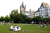 People sitting in a park in the old town with St. Martin Church in the background, Cologne, North Rhine Westphalia, Germany, Europe