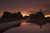 Dramatic sunset, low tide, Corbiere lighthouse, St. Ouens, Jersey, Channel Islands, United Kingdom, Europe