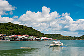 Auslegerkanu, Ausflugsboot und Häuser auf Stelzen, Coron, Busuanga, Palawan, Philippinen, Asien