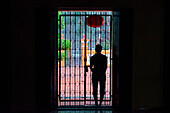 Silhouette von Mann in Tür von Tempel während Regenschauer, Ho-Chi-Minh-Stadt (Saigon), Ho Chi Minh, Vietnam, Asien