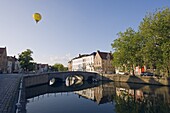 Hot air balloon floating over rooftops, houses reflected in a canal, old town, UNESCO World Heritage Site, Bruges, Flanders, Belgium, Europe
