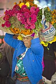 Woman carrying flowers at Tlacolula Sunday market, Oaxaca state, Mexico, North America