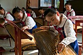 Young girls playing traditional instruments in the Schoolchildrens palace, Pyongyang, North Korea, Asia