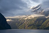 Clouds hang in the narrow entrance from the Sunnylvsfjord and the Storfjord, Geiranger Fjord, UNESCO World Heritage Site, west coast, Norway, Scandinavia, Europe