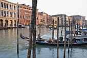 Evening light shines onto building lining the Grand Canal by the Rialto Bridge, Venice, UNESCO World Heritage Site, Veneto, Italy, Europe