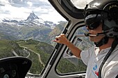 Helicopter pilot, Air Zermatt, and view of the Matterhorn, Zermatt, Valais, Swiss Alps, Switzerland, Europe