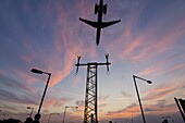 DC9 aircraft approaching over runway landing light gantries at sunset, London, England, United Kingdom, Europe