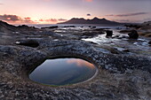 View towards Isle of Rum at sunset from rock formation at Laig Bay, Isle of Eigg, Inner Hebrides, Scotland, United Kingdom, Europe
