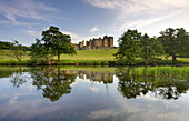Alnwick Castle reflecting in River Aln, Alnwick, Northumberland, England, United Kingdom, Europe
