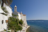 Swimmers and sunbathers on rock wall next to Rab Town, island of Rab, Kvarner region, Croatia, Europe