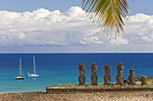 Anakena beach,  yachts moored in front of the monolithic giant stone Moai statues of Ahu Nau Nau,  four of which have topknots,  Rapa Nui (Easter Island),  UNESCO World Heritage Site,  Chile,  South America
