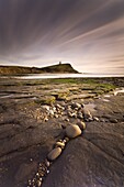 View across Kimmeridge Bay at dusk towards Hen Cliff and Clavell Tower, Perbeck District, Dorset, England, United Kingdom, Europe