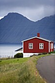 Houses at Hellur, small village near Oyndarfjordur, cliffs of Kalsoy Island in background, Eysturoy, Faroe Islands (Faroes), Denmark, Europe