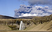 Distant view of the Seljalandsfoss waterfall with the ash plume of the Eyjafjallajokull eruption in the distance, near Hella, southern Iceland, Iceland, Polar Regions