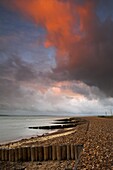 A blazing orange cloud above Lepe Beach in the New Forest National Park, Hampshire, England, United Kingdom, Europe