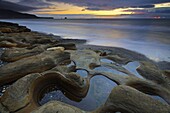 Spectacular sunset and sandstone formations on Seven Mile Beach, near Greymouth, South Island, New Zealand, Pacific