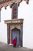 Buddhist monk running towards a doorway at Trongsa Dzong, Trongsa, Bhutan, Asia