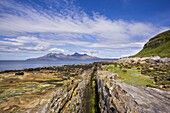 Basalt dyke on Eigg with the Isle of Rum in the distance, Isle of Eigg, Inner Hebrides, Scotland, United Kingdom, Europe