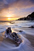 Surging waves break on the rocky shore at Westcombe Beach in South Devon, England, United Kingdom, Europe