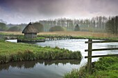 Thatched fisherman's hut and eel traps spanning the River Test near Leckford, Hampshire, England, United Kingdom, Europe