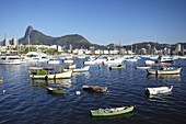 Boats moored in the harbour with Christ the Redeemer statue in background, Urca, Rio de Janeiro, Brazil, South America