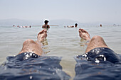 Mann liegt im Wasser des Toten Meeres, Masada, Totes Meer, Israel
