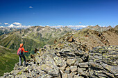 Woman hiking ascending on ridge towards Gleirscher Rosskogel, Gleirscher Rosskogel, Sellrain, Stubai Alps, Tyrol, Austria