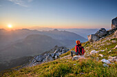 Frau beim Wandern blickt auf Sonnenaufgang über Mont Blanc-Gruppe, La Tournette, Hochsavoyen, Frankreich